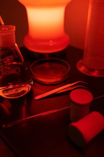a pair of scissors sitting on top of a table, glowing potions, red light bulbs, in a lab, profile image