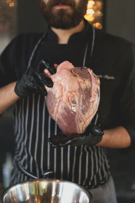 a man holding a piece of meat in a kitchen, glass-cast heart, hanging veins, skye meaker, large head