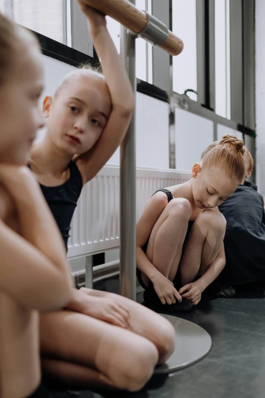 a group of young children sitting on the floor, by Matija Jama, trending on pexels, antipodeans, standing in front of a mirror, movie still of a tired, ballet dancer, girl silver ponytail hair