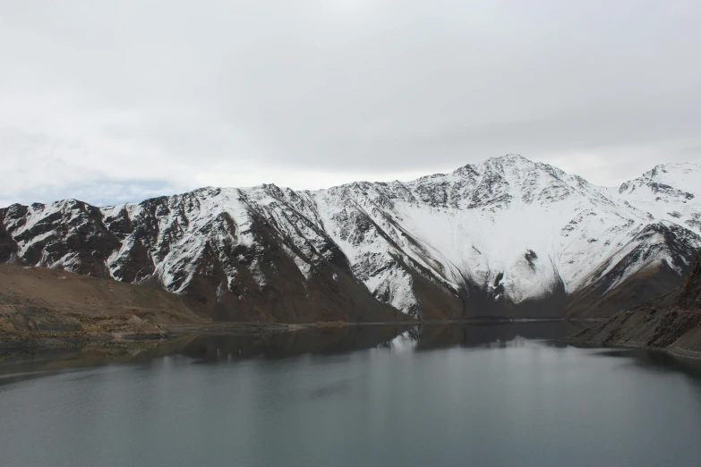 a large body of water surrounded by snow covered mountains, by Muggur, nature photo, grey, tourist photo, trending photo