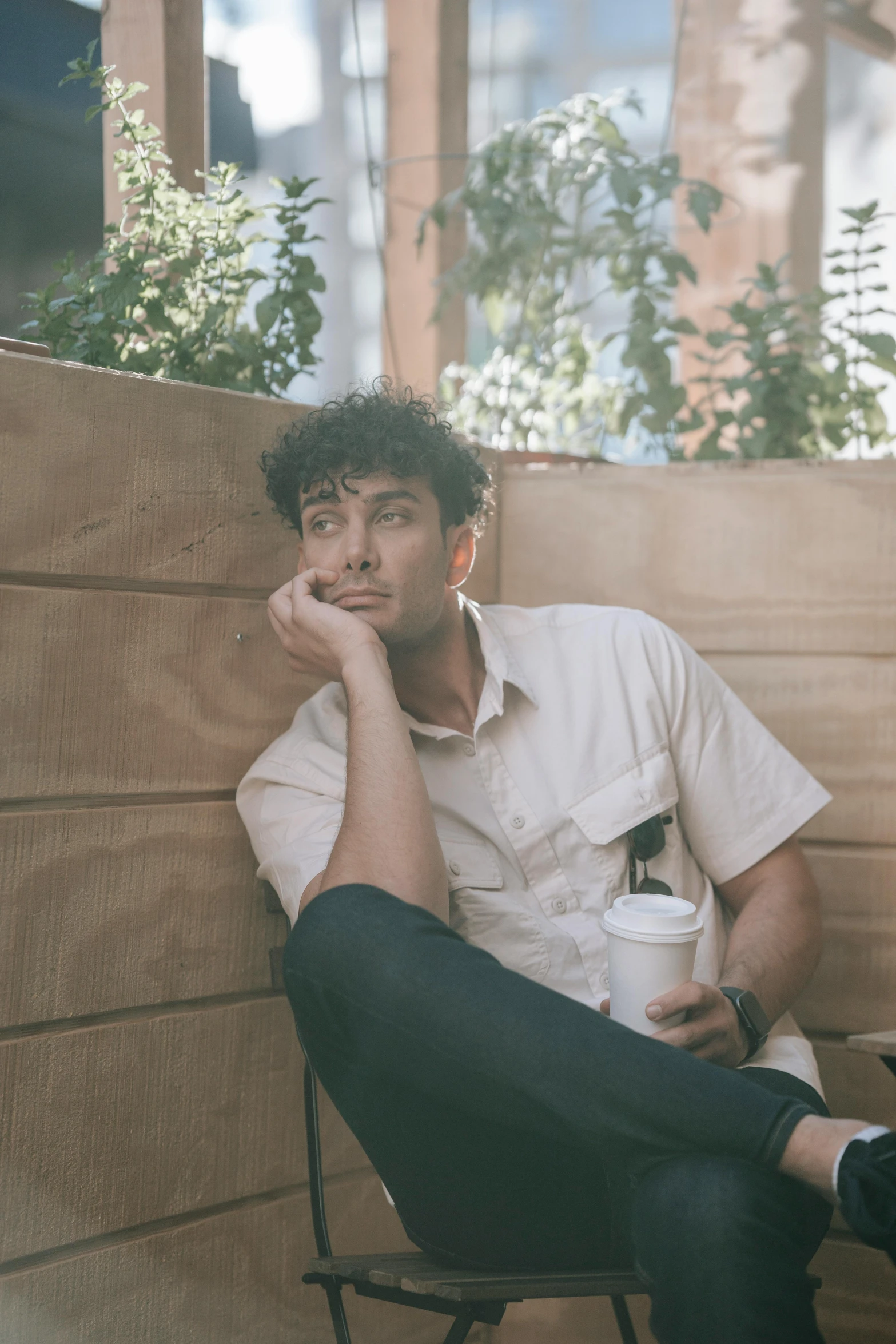 a man sitting on a chair talking on a cell phone, an album cover, by Adam Dario Keel, pexels contest winner, lean man with light tan skin, thoughtful ), sitting on a bench, with a white mug