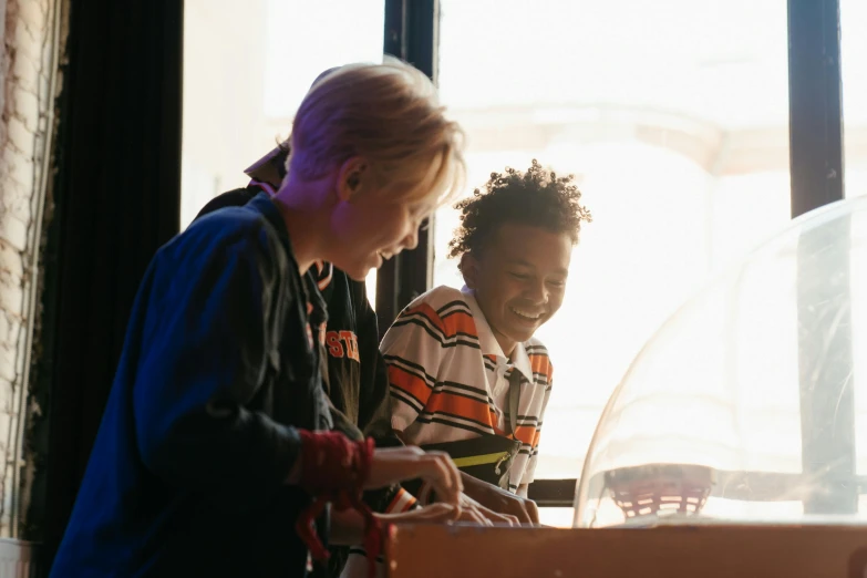 a couple of kids standing next to each other, pexels, interactive art, a busy arcade, orrery, both laughing, thumbnail