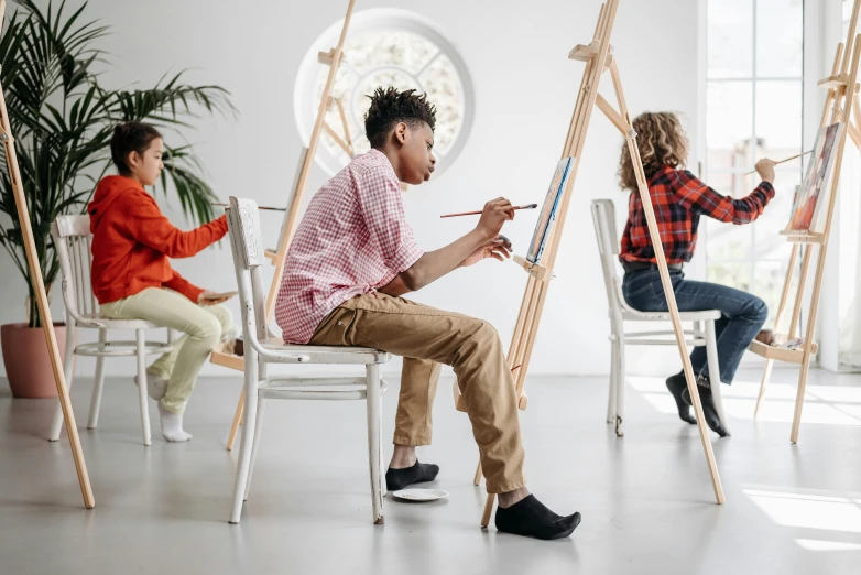 a group of people painting in an art studio, pexels contest winner, kid drawing, in style of norman rockwell, minimalistic art, easel