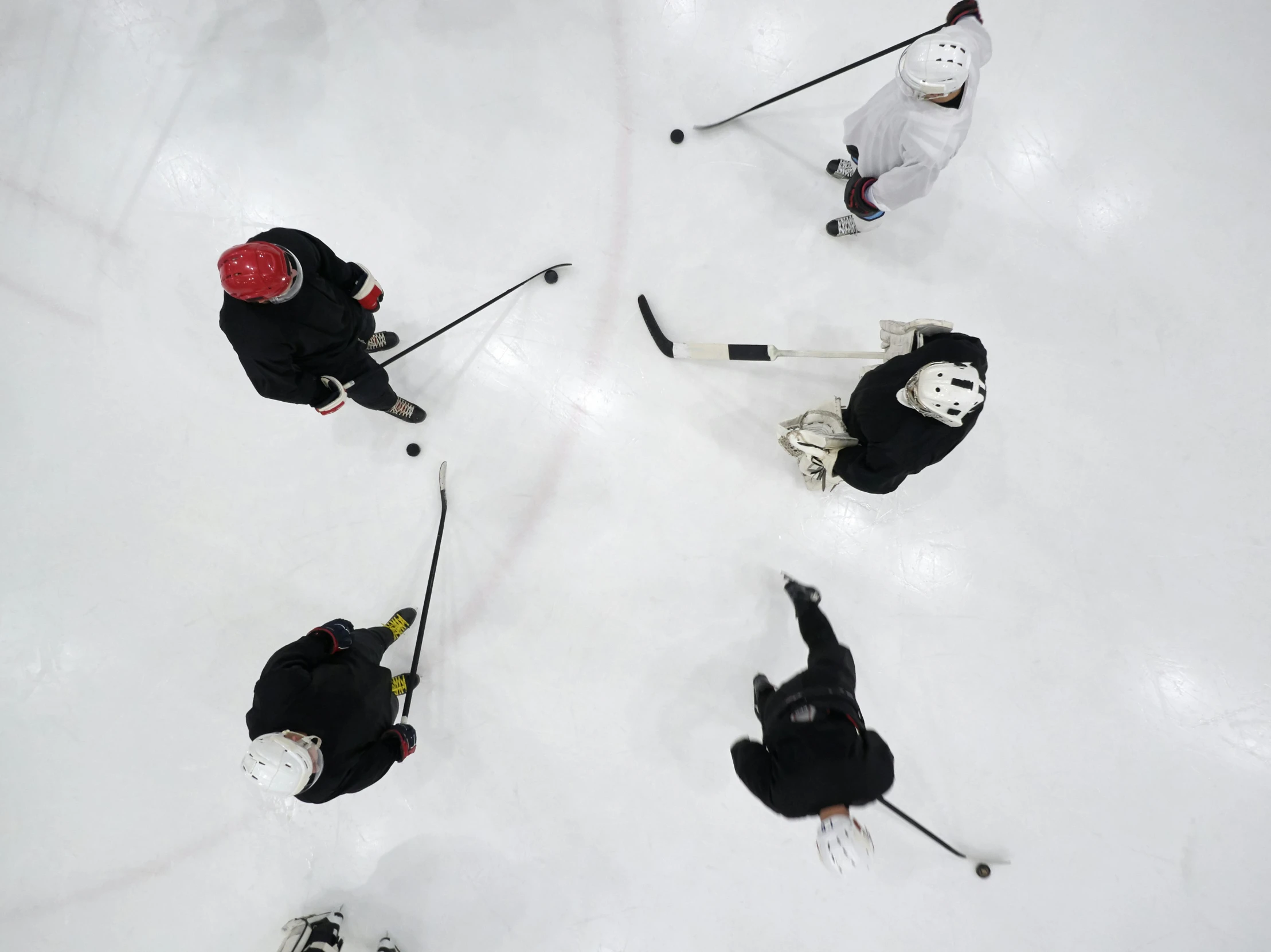 a group of people riding skis on top of a snow covered slope, hockey mask, game top down view, photographed for reuters, boston