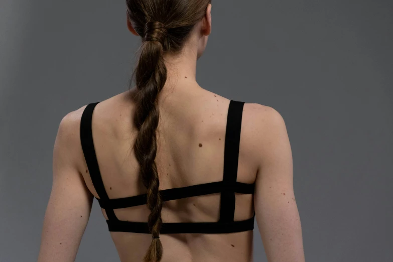 a woman with a braid in her hair, an album cover, inspired by Vanessa Beecroft, unsplash, detailed sports bra, back - view, marvelous designer, harnesses