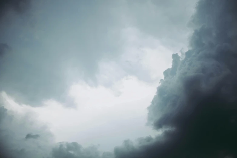 there is a plane that is flying in the sky, inspired by Elsa Bleda, unsplash, minimalism, dark mammatus cloud, alessio albi, grey, low-angle