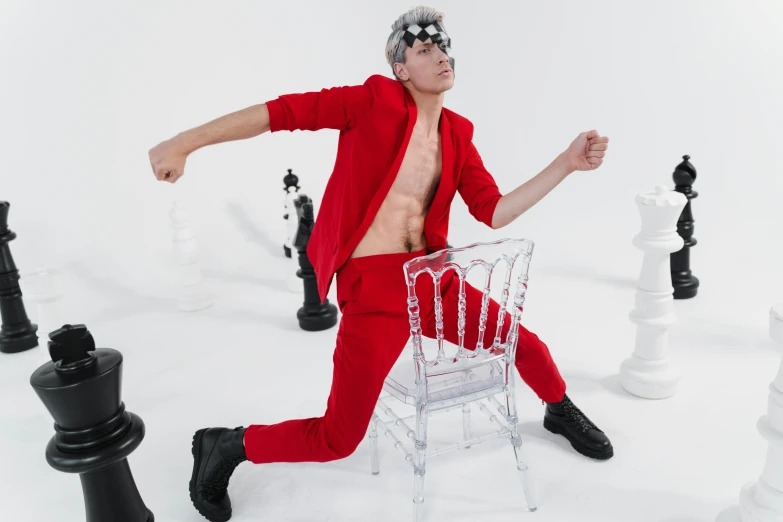 a man sitting in a chair surrounded by chess pieces, an album cover, inspired by Anton Fadeev, pexels contest winner, antipodeans, red body suit, an epic non - binary model, man standing in defensive pose, quicksilver