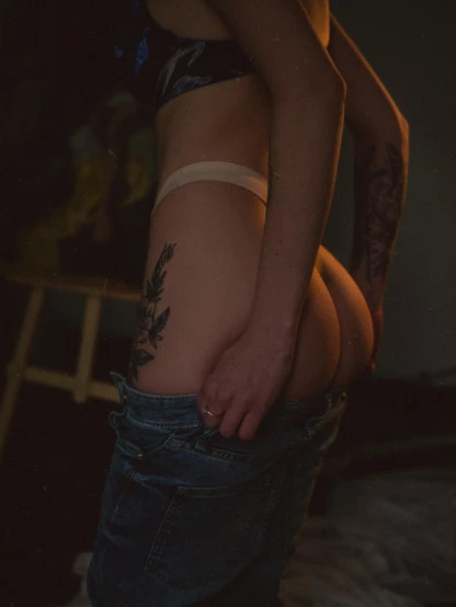 a woman with a tattoo on her stomach, inspired by Elsa Bleda, unsplash contest winner, in a basement, toned derriere, 🐎🍑, low quality photo
