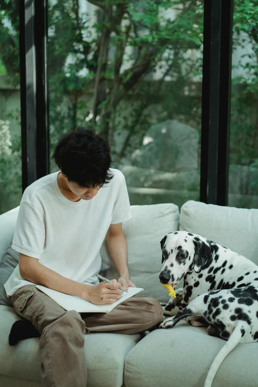 a man sitting on a couch with a dalmatian dog, a drawing, pexels contest winner, writing in journal, wonbin lee, gif, teenage boy