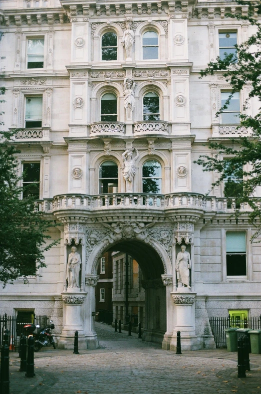 a large white building with a lot of windows, a statue, inspired by Christopher Wren, pexels contest winner, archway, old apartment, huge gate, london