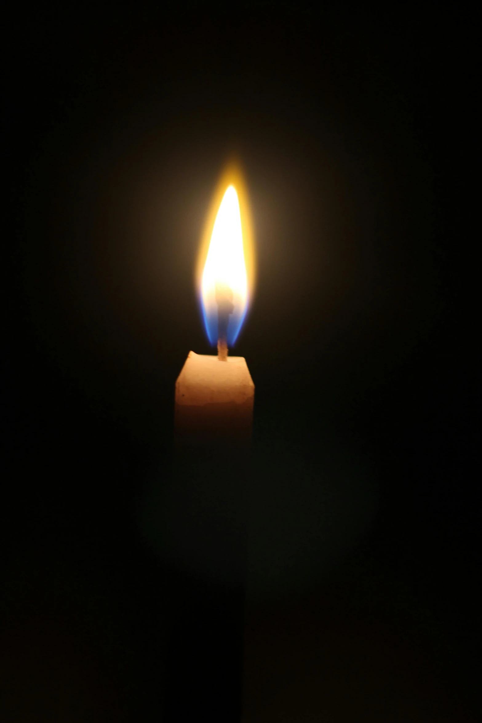 a lit candle in the dark, light and dark, taken in the late 2010s, contain