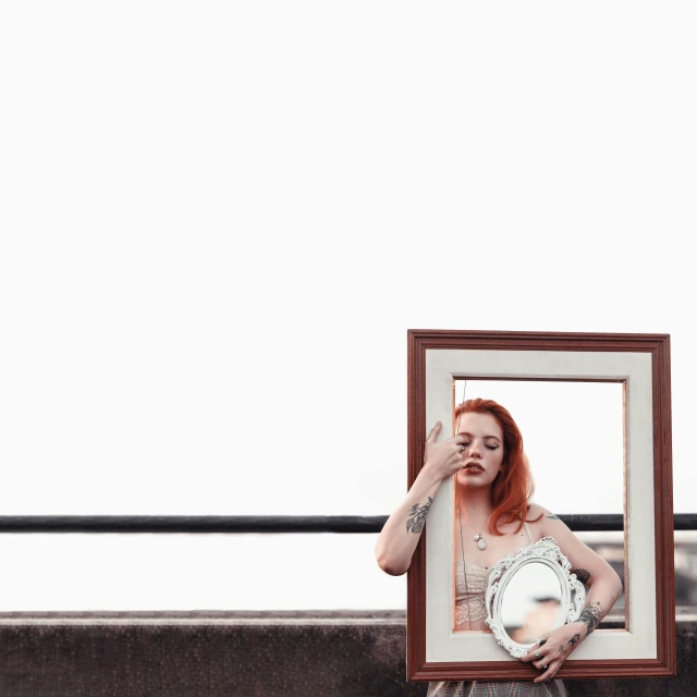 a woman holding a picture frame in front of her face, a photo, inspired by Elsa Bleda, pexels contest winner, surrealism, redhead woman, transparent glass woman, full body framing, with a round face