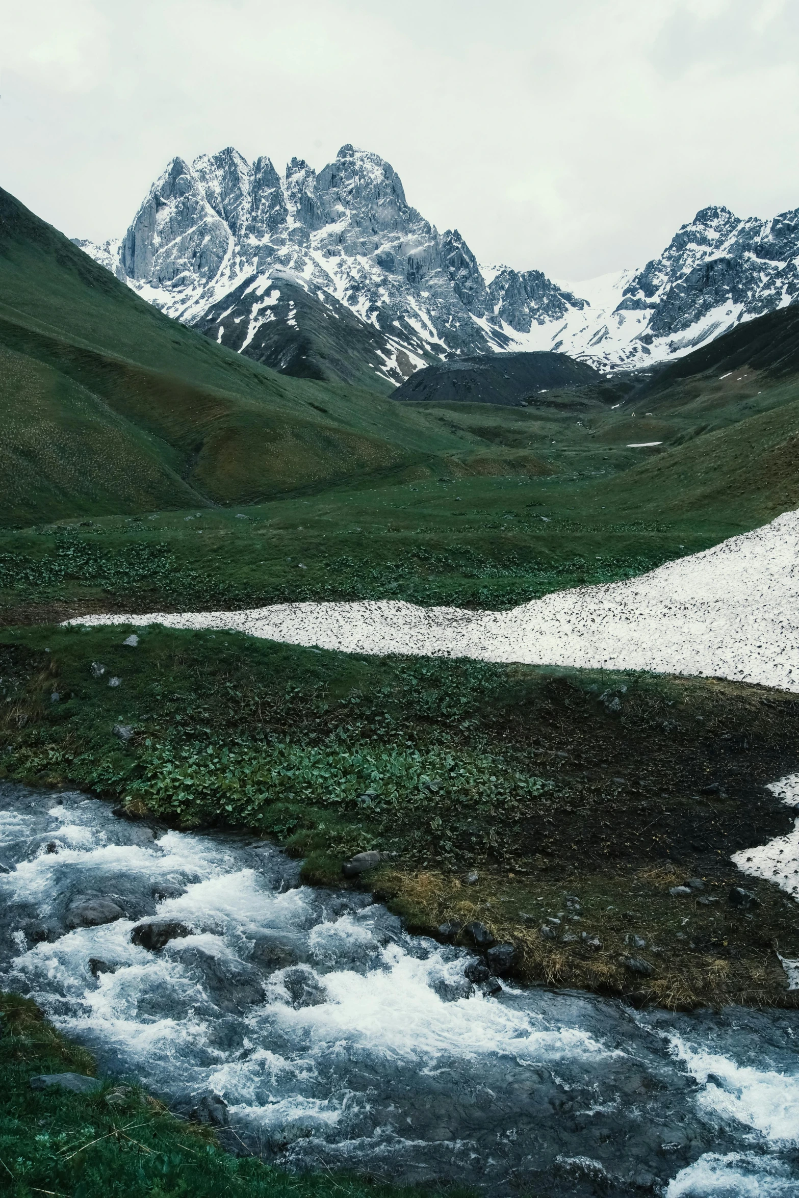 a river running through a lush green valley, hurufiyya, mountain snow, taken with kodak portra, adar darnov, high