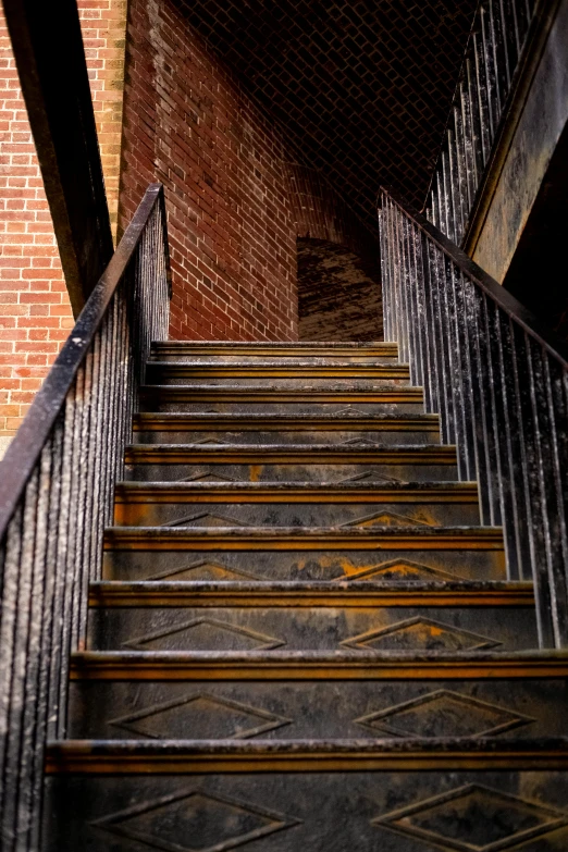 a set of stairs leading up to a brick building, by Joe Stefanelli, unsplash, arts and crafts movement, extreme intricate metal details, rusting, slate, gold