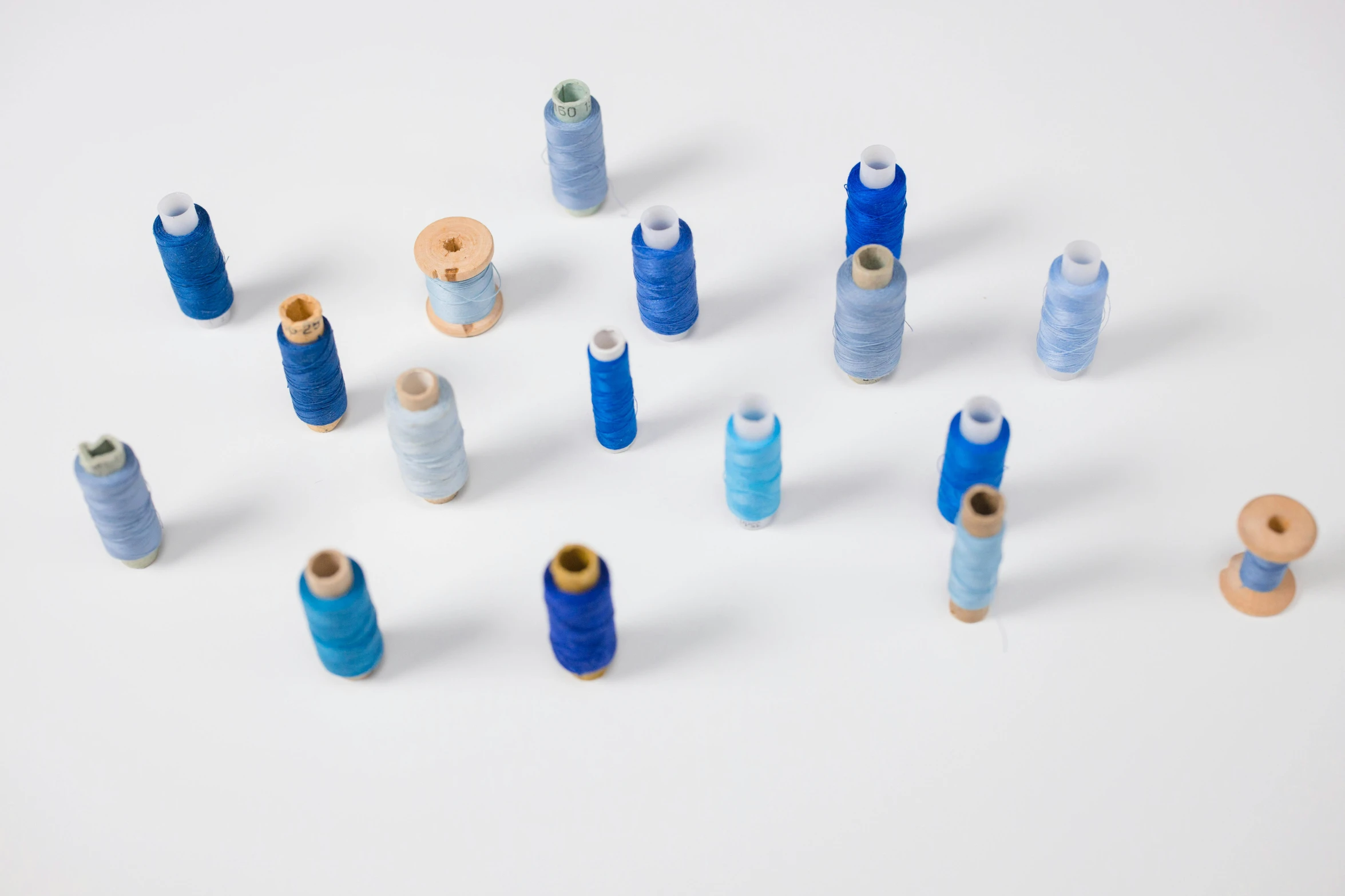 a number of spools of thread on a white surface, by Daniel Gelon, unsplash, wearing blue, ignant, 4 0 0 0 samples, product introduction photo