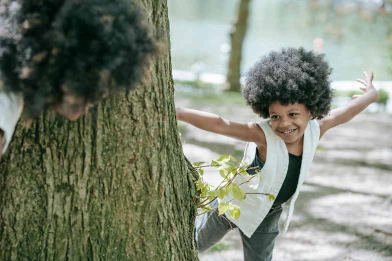 a little boy that is standing next to a tree, pexels contest winner, super cute funky black girl, playing, thumbnail, sustainable materials