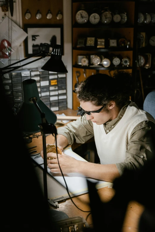 a man sitting at a desk writing on a piece of paper, by Lee Loughridge, instagram, arbeitsrat für kunst, wearing victorian brass goggles, archeologial dig setting, backlit, stitching