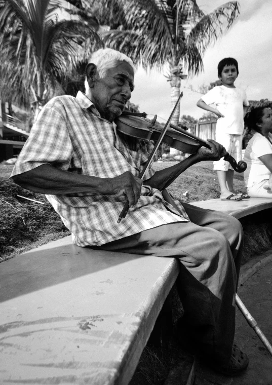 a black and white photo of a man playing a violin, by Joze Ciuha, people watching around, florida man, peruvian looking, an elderly