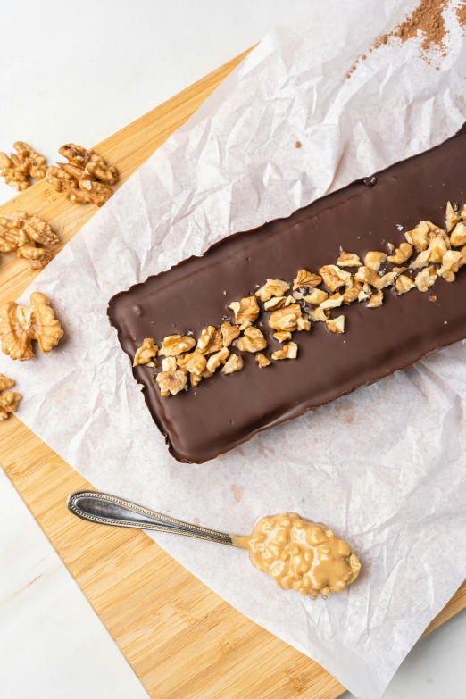 a chocolate bar sitting on top of a wooden cutting board, les nabis, walnuts, cake, thumbnail, glazed