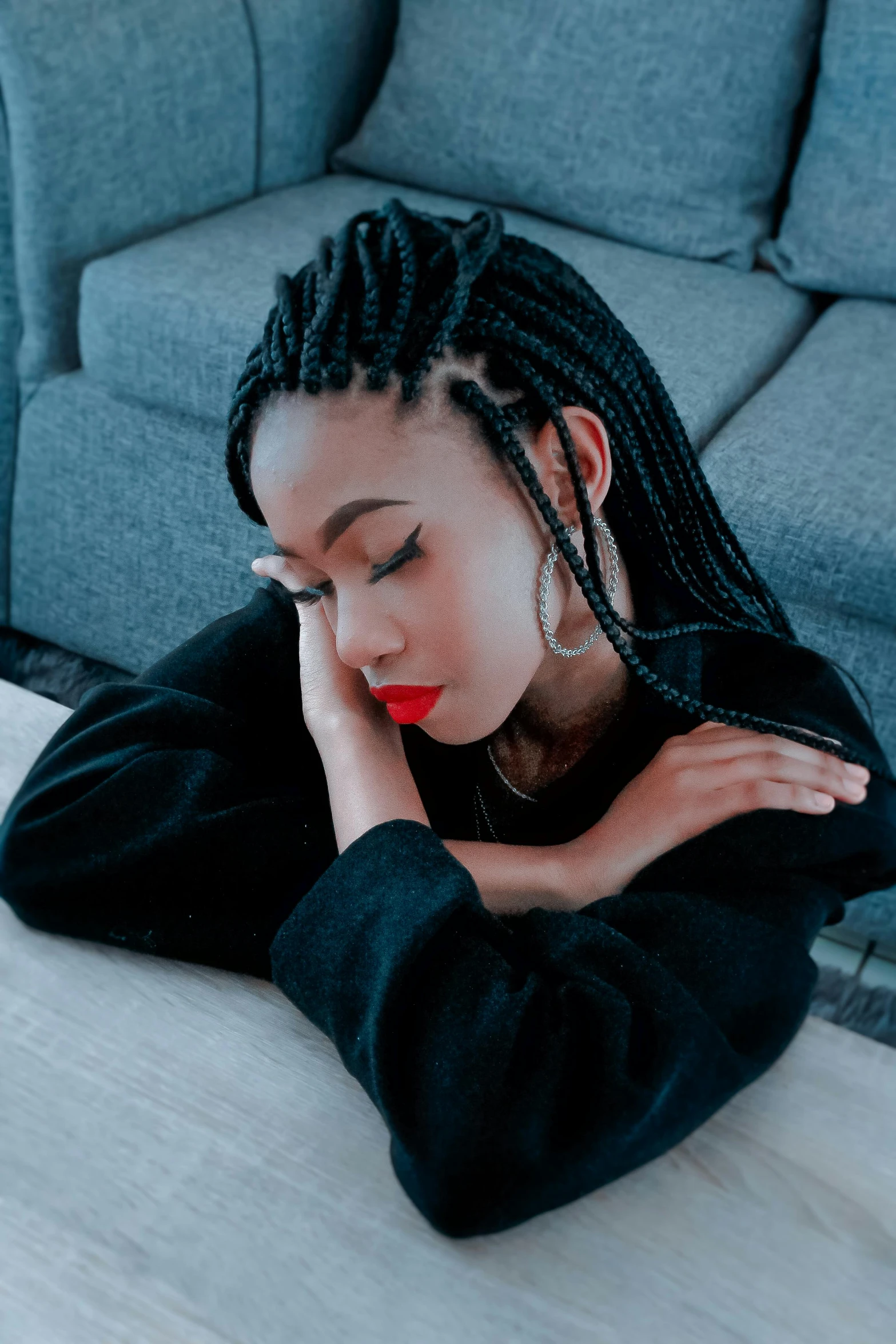 a woman sitting at a table with a laptop, an album cover, inspired by Lily Delissa Joseph, trending on pexels, long black braids, profile image, pouting, on a couch