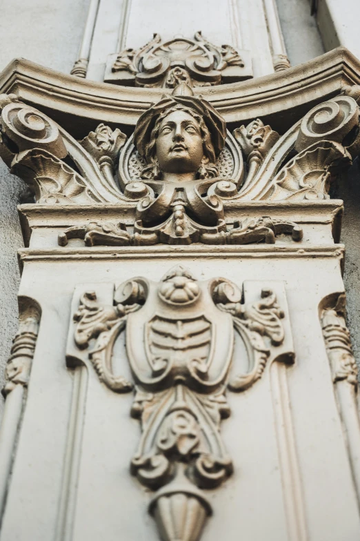 a statue that is on the side of a building, inspired by Luca della Robbia, neoclassicism, intricate facial details, intricate details in the frames, art nouveau accents, white mechanical details