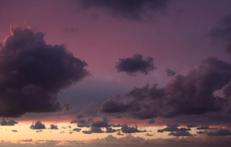 a large body of water under a cloudy sky, by Andrew Geddes, unsplash, romanticism, purple and pink, layered stratocumulus clouds, humid evening, high quality photo