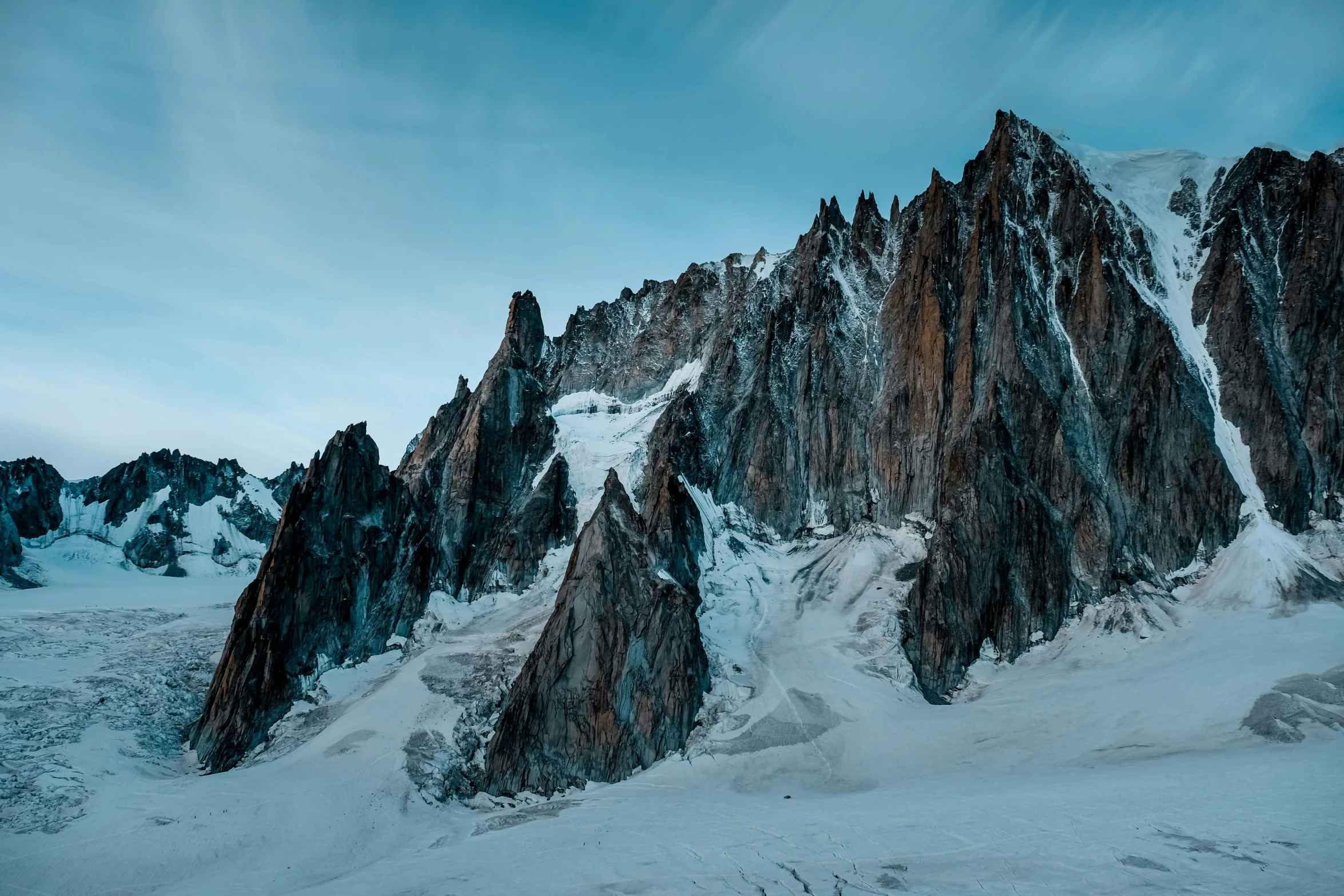 a mountain covered in snow under a blue sky, by Pierre Mion, pexels contest winner, tall stone spires, rugged face, alessio albi, extra high resolution