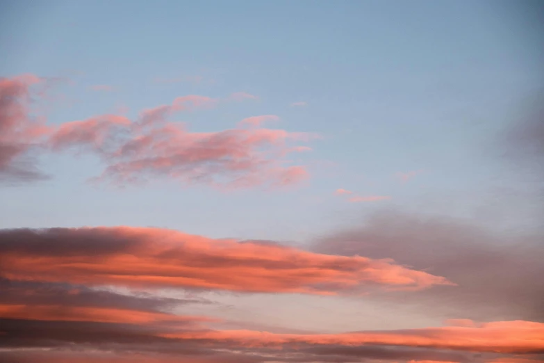 a couple of kites that are flying in the sky, unsplash, aestheticism, redpink sunset, layered stratocumulus clouds, blue hour photography, pink