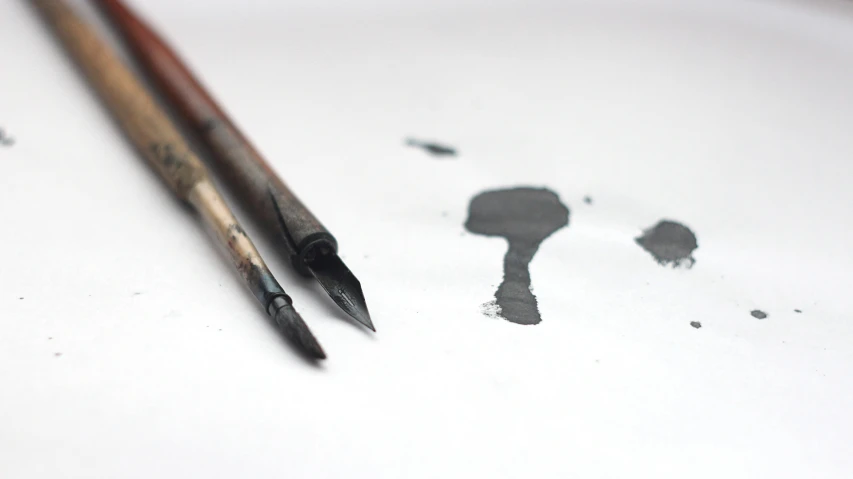 a pair of paint brushes sitting on top of a piece of paper, an ink drawing, inspired by Kyffin Williams, pexels, black paint drops, traditional animation, grey, water color