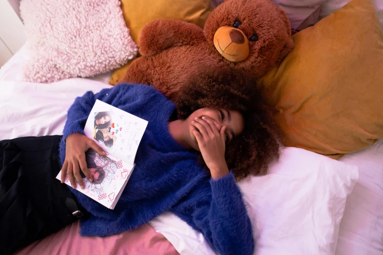 a woman laying on top of a bed next to a teddy bear, a cartoon, by Julia Pishtar, pexels contest winner, nerdy black girl super hero, reading for a party, magazine photo, frizzy hair