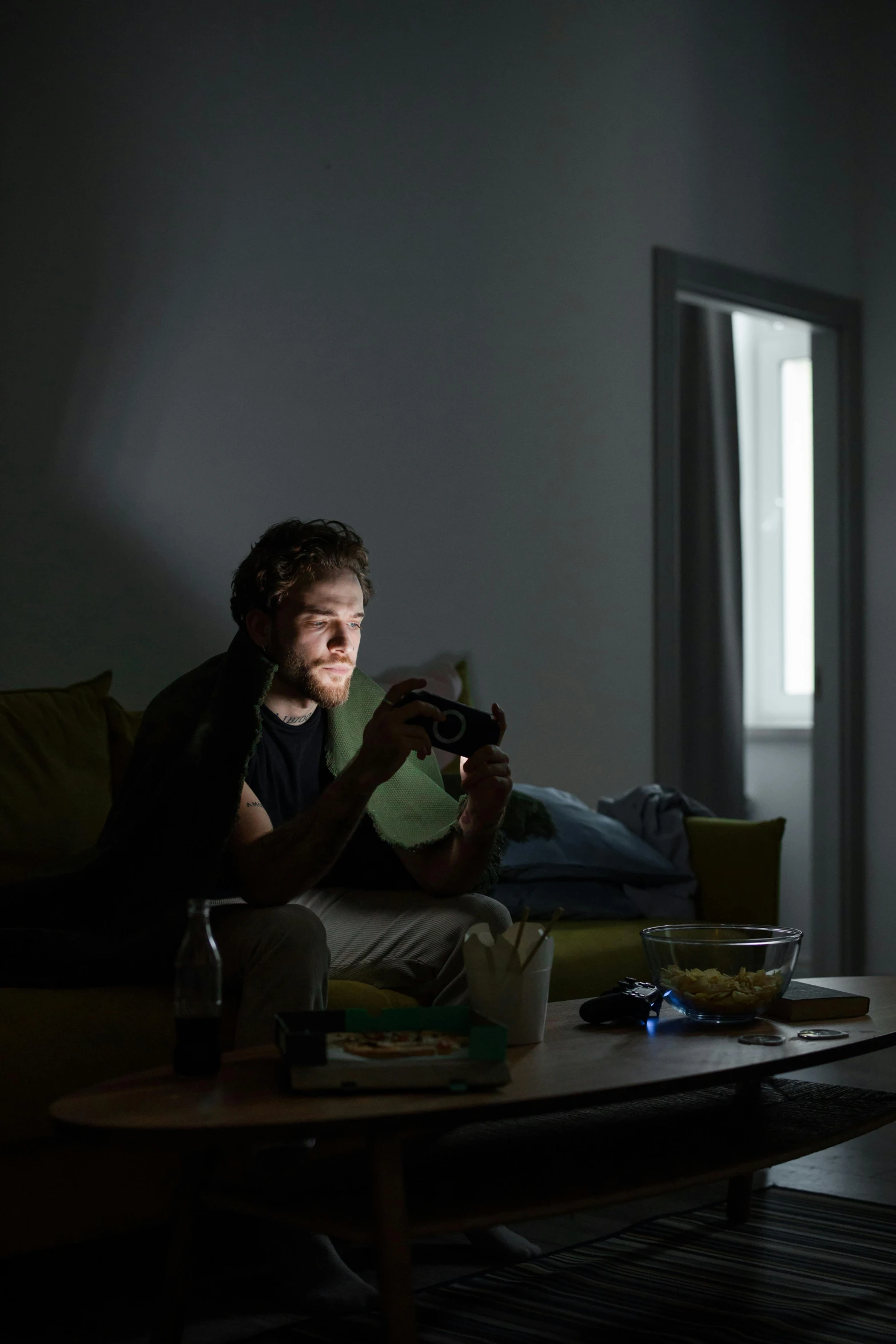 a man sitting on a couch watching tv, inspired by Gregory Crewdson, pexels contest winner, night vision goggles, playing games, lawther sit at table playing dnd, window light