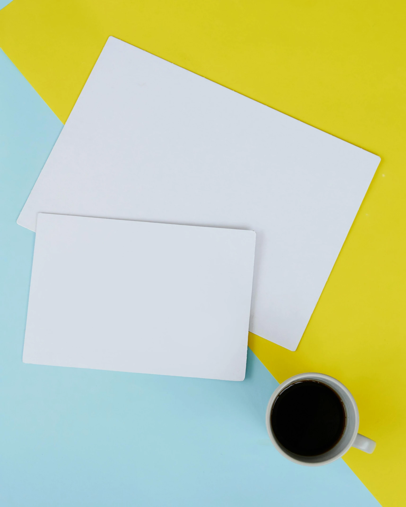 blank paper and a cup of coffee on a blue and yellow background, inspired by Kazimir Malevich, unsplash, pair of keycards on table, whiteboards, square, large and tall