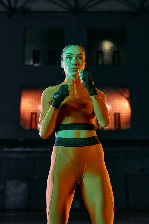 a woman standing on top of a tennis court holding a racquet, wearing urban techwear, orange glow, boxing gloves, wearing tight suit