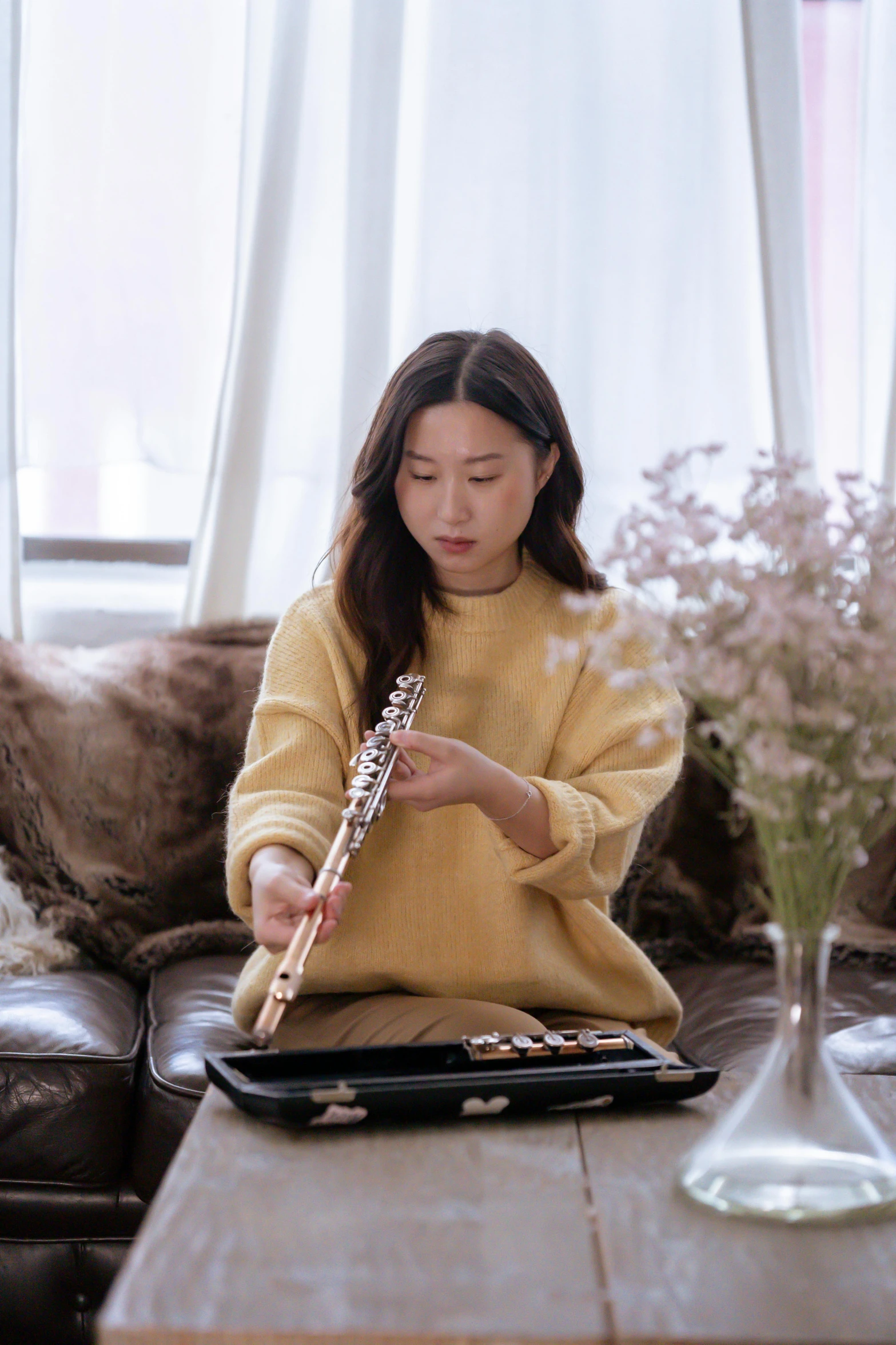 a woman sitting on a couch playing a flute, an album cover, inspired by Song Xu, pexels contest winner, jaeyeon nam, performance, 🚿🗝📝