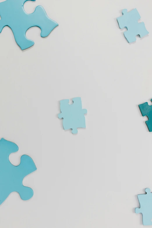 a blue puzzle piece laying on top of a white surface, by Carey Morris, trending on unsplash, 64x64, animation, patterned, scattered props