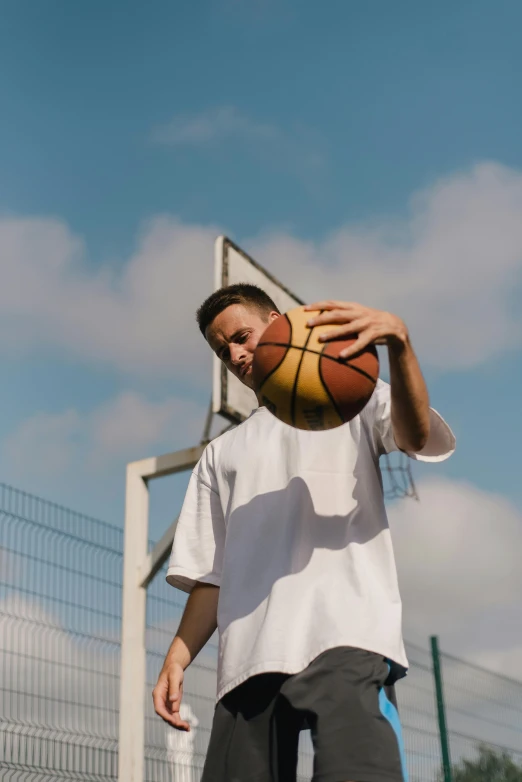 a man holding a basketball on top of a basketball court, wearing a white button up shirt, uniform off - white sky, action sports, 2019 trending photo