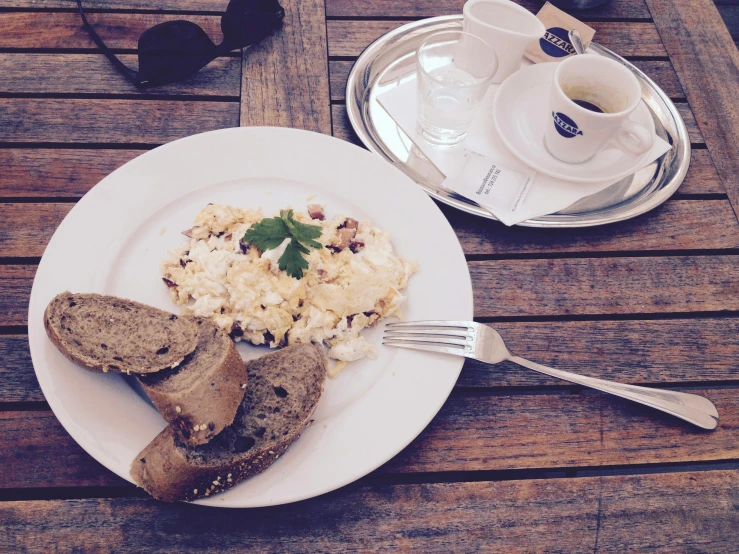 a plate of food sitting on top of a wooden table, by Lucia Peka, pexels contest winner, happening, breakfast, french noveau, hard boiled, swedish