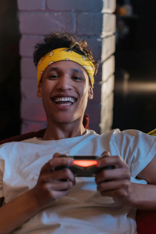 a woman sitting on a couch playing a video game, trending on pexels, renaissance, gang saints wear yellow bandanas, brown skin man with a giant grin, ashteroth, smiling male