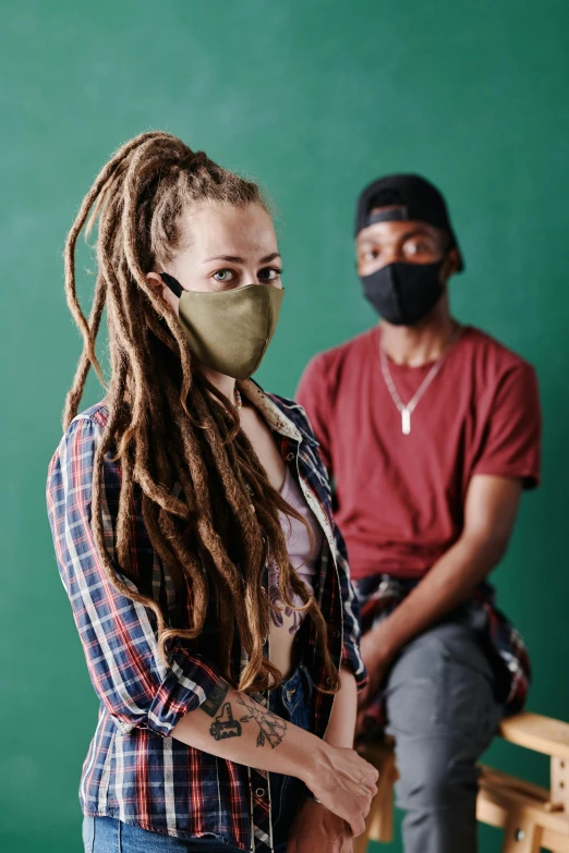 a woman with dreadlocks standing next to a man wearing a face mask, a portrait, by Jeka Kemp, trending on pexels, school class, hot topic, vine, photo from a promo shoot