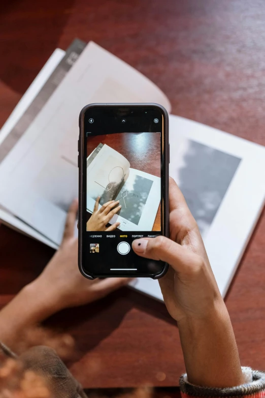 a person taking a picture with a cell phone, on high-quality paper, curated collections, multiple stories, high resolution image