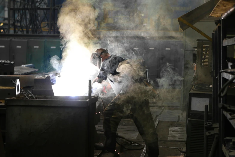 a man welding a piece of metal in a factory, pexels contest winner, arbeitsrat für kunst, smoke and thick dust in the air, australian, grey, an ultra realistic