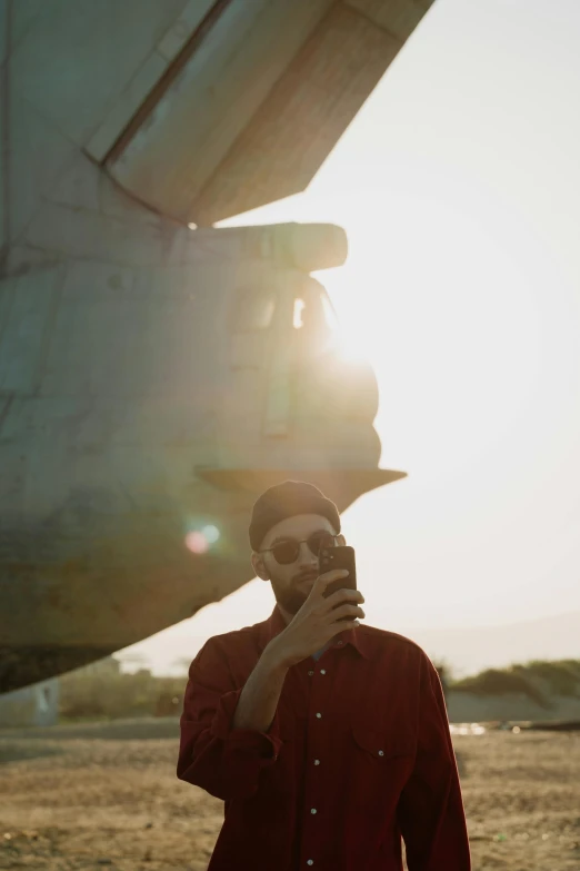 a man taking a picture of himself in front of an airplane, a picture, pexels contest winner, sunfaded, portrait of tall, phone photo, low light