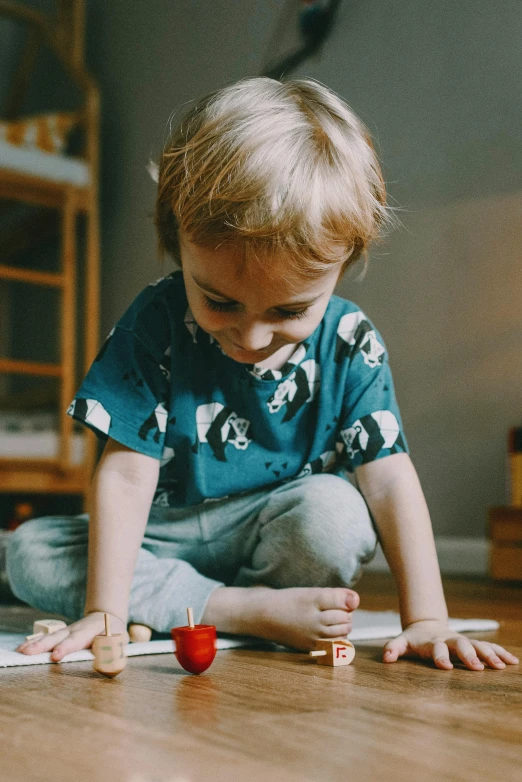 a little boy sitting on the floor playing with toys, by Jesper Knudsen, pexels contest winner, visual art, board games on a table, gif, loving stare, looking serious