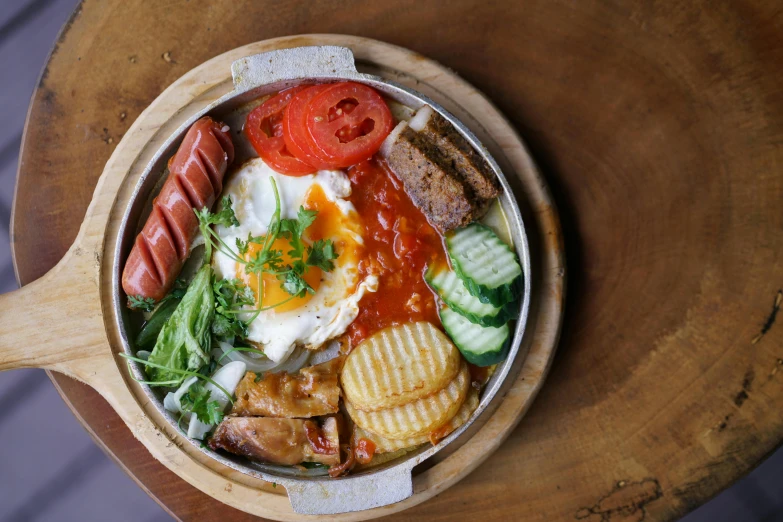 a bowl of food sitting on top of a wooden table, a picture, on a plate