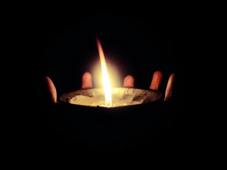 a hand holding a lit candle in the dark, a picture, by Bernard Meninsky, pexels, instagram post, with a black background, uploaded, image