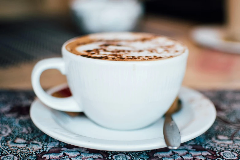 a close up of a cup of coffee on a saucer, by Niko Henrichon, trending on unsplash, fan favorite, cappuccino, background image, multiple stories