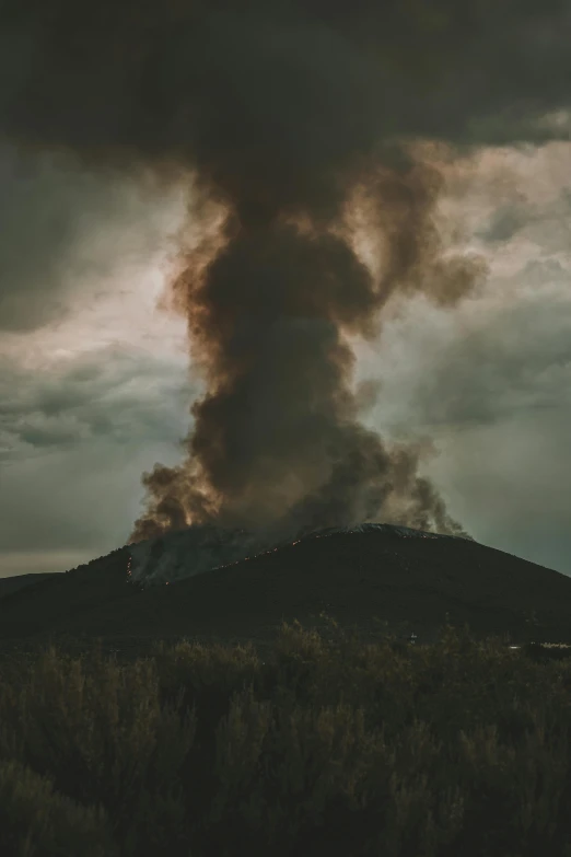 a large plume of smoke rising from the top of a mountain, by Lee Loughridge, unsplash contest winner, destroyed human structures, paul barson, todd hido photography, craters