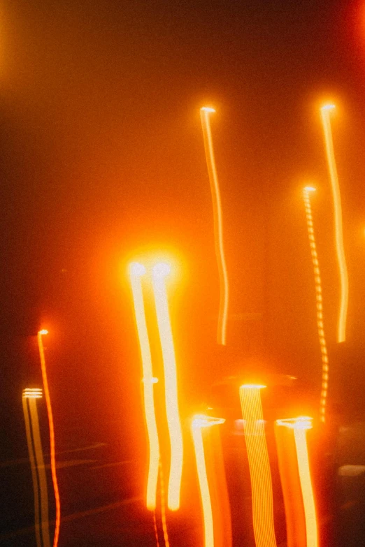 a bunch of lights that are in the dark, an album cover, pexels, lyrical abstraction, orange yellow ethereal, glowing candles, streetlights, streak lights