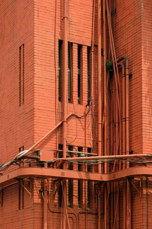 a fire hydrant in front of a red brick building, inspired by Ricardo Bofill, bengal school of art, cable wires, photograph from above, buttresses, steel archways