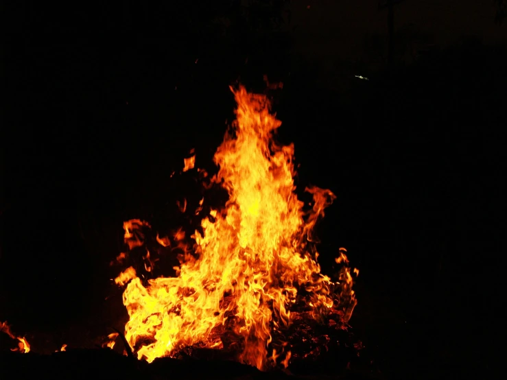 a bonfire is lit up in the dark, an album cover, pexels, hurufiyya, fuming effigy, taken in the late 2010s, 2045, flamboyant